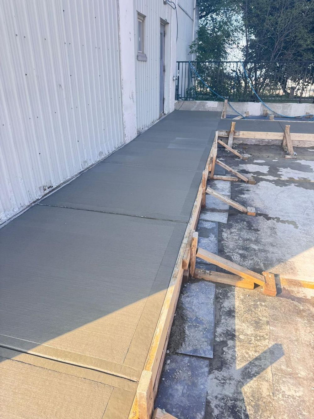 Freshly placed concrete sidewalk pad